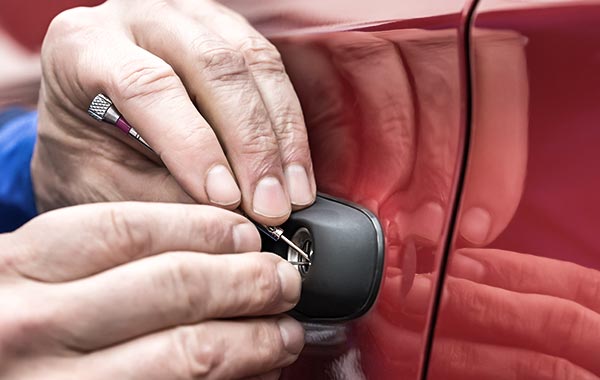 Hand Holding Lockpicker To Open Car Door